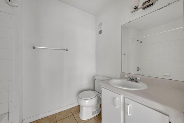 bathroom featuring tile patterned floors, toilet, vanity, and a tile shower