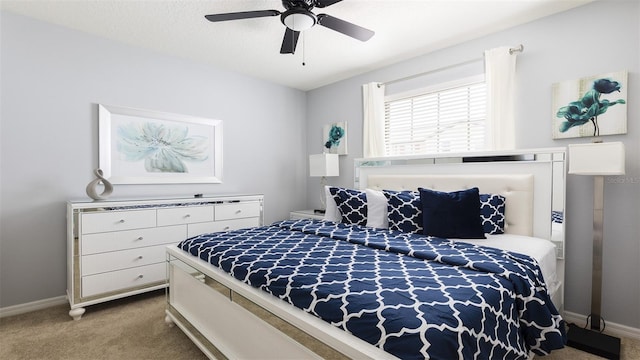 carpeted bedroom featuring ceiling fan and a textured ceiling