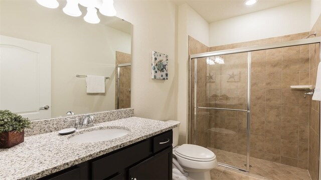 bathroom with vanity, toilet, and a shower with shower door