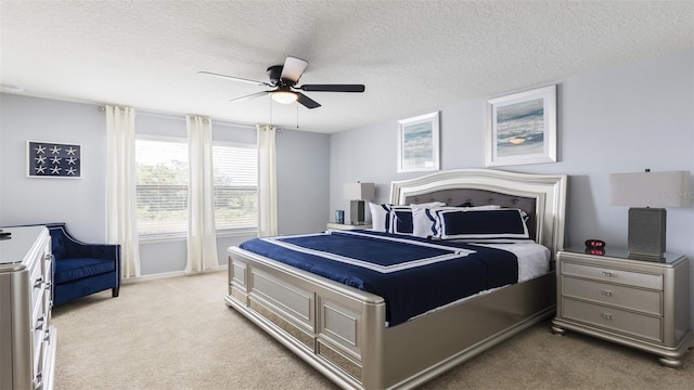 carpeted bedroom featuring ceiling fan and a textured ceiling