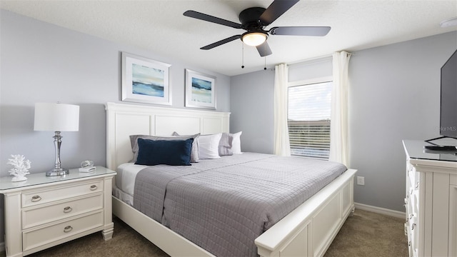 carpeted bedroom with ceiling fan and a textured ceiling