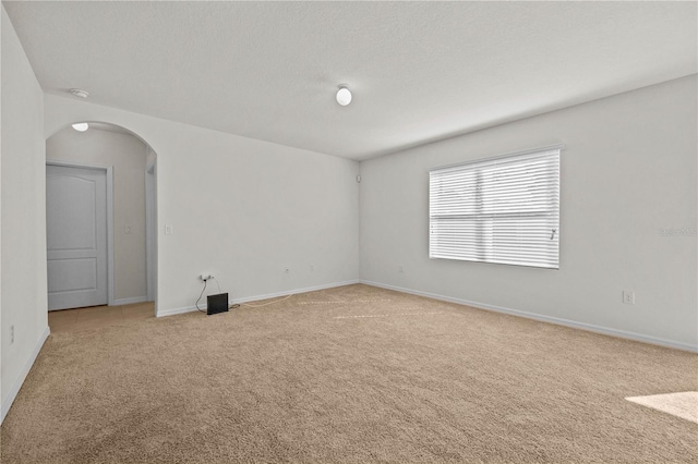 carpeted empty room featuring a textured ceiling