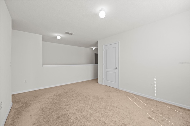 empty room with carpet floors and a textured ceiling