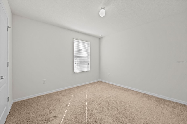 carpeted empty room with a textured ceiling