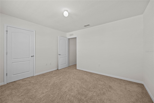 carpeted spare room featuring a textured ceiling