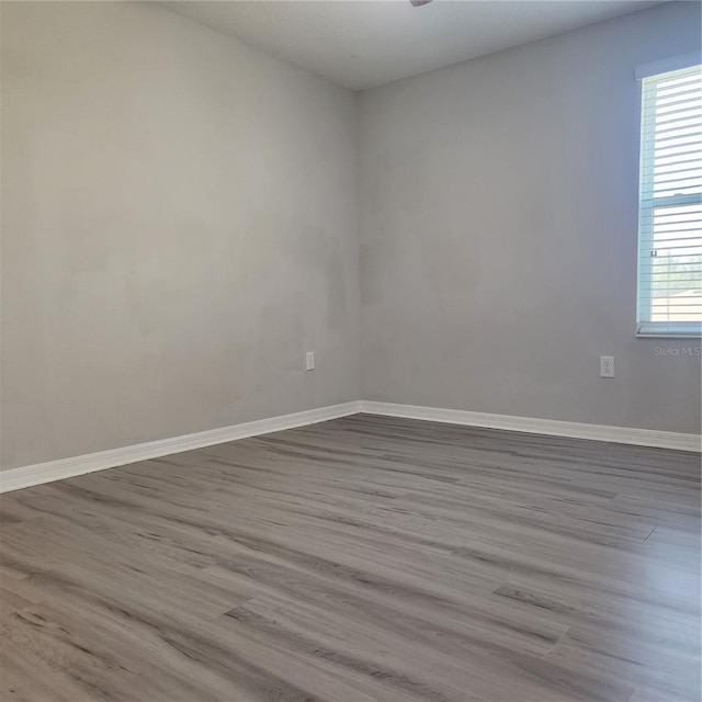 empty room featuring baseboards and wood finished floors