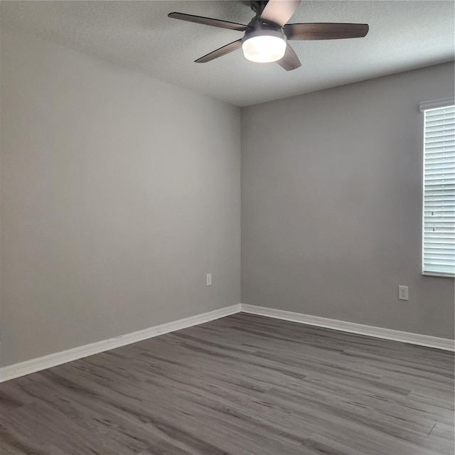 unfurnished room with dark wood-style floors and baseboards