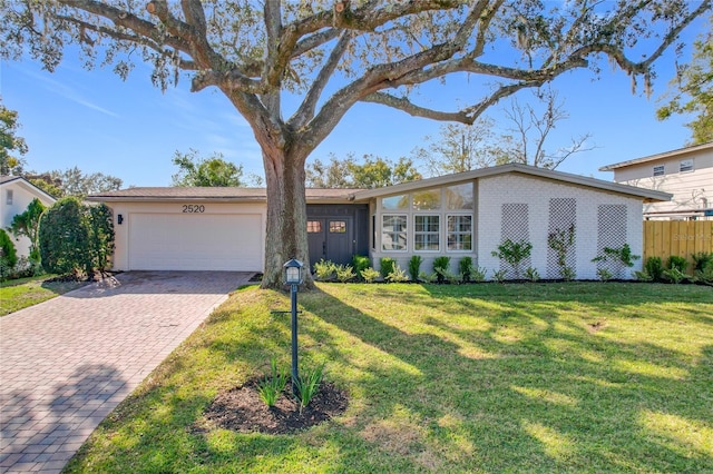 ranch-style house featuring a garage and a front yard