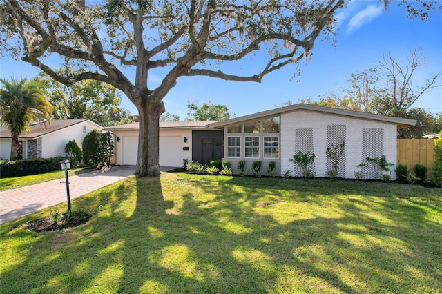 ranch-style house featuring a garage and a front yard