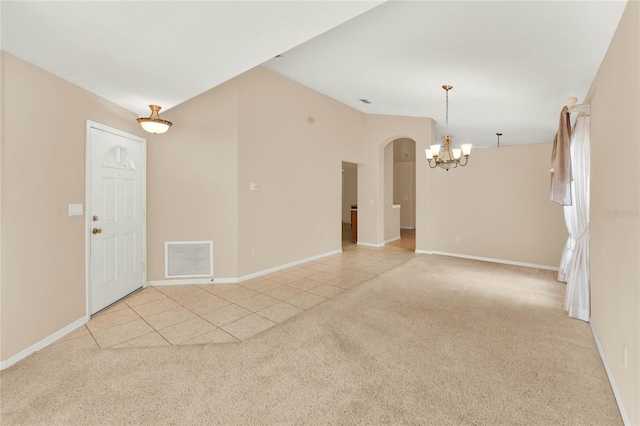 spare room featuring a notable chandelier, lofted ceiling, and light colored carpet