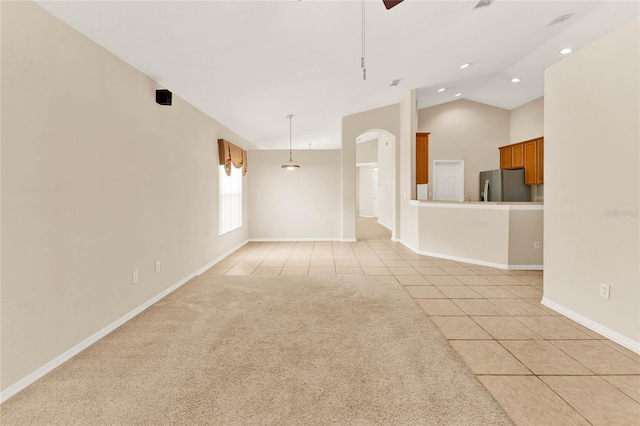 unfurnished living room featuring lofted ceiling, ceiling fan, and light tile patterned floors