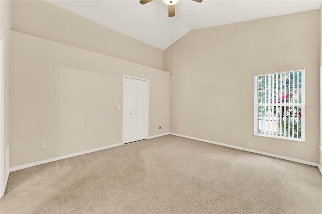 carpeted empty room featuring high vaulted ceiling and ceiling fan