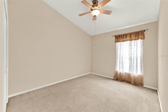 carpeted spare room with ceiling fan and vaulted ceiling