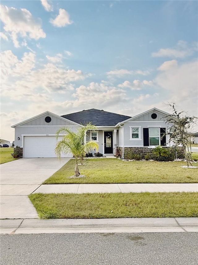 ranch-style home featuring a garage and a front lawn