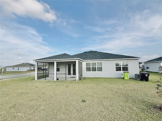 back of property featuring a sunroom and a yard