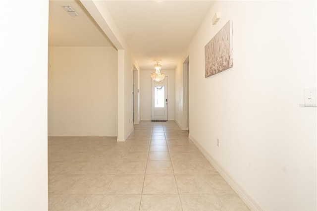 interior space with visible vents, a notable chandelier, baseboards, and light tile patterned floors