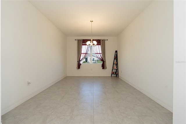 empty room featuring a chandelier, baseboards, and light tile patterned floors