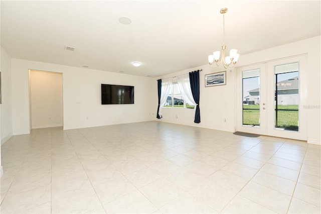 empty room featuring baseboards, french doors, visible vents, and a notable chandelier