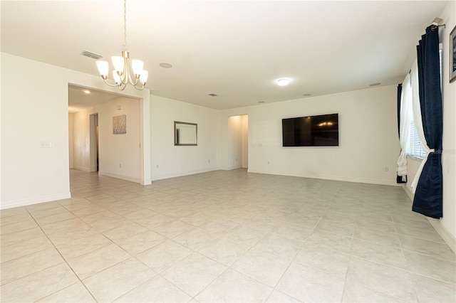 spare room with a chandelier, light tile patterned flooring, visible vents, and baseboards