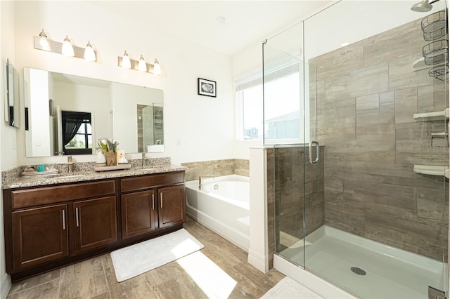 bathroom with a garden tub, a shower stall, a wealth of natural light, and vanity