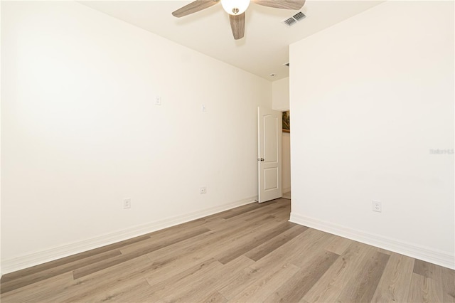 empty room with light wood-type flooring, visible vents, ceiling fan, and baseboards