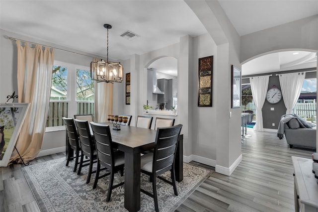 dining area with a chandelier and light hardwood / wood-style flooring