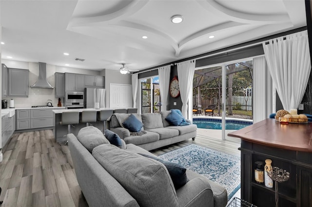 living room featuring ceiling fan and light hardwood / wood-style flooring