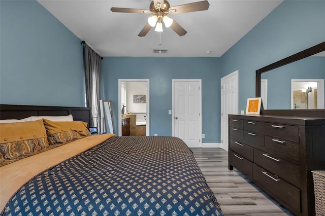 bedroom featuring ceiling fan, ensuite bath, and light hardwood / wood-style flooring