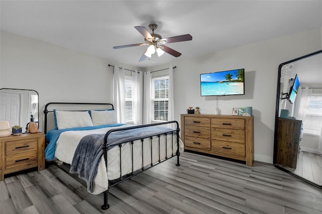 bedroom featuring multiple windows, hardwood / wood-style floors, and ceiling fan