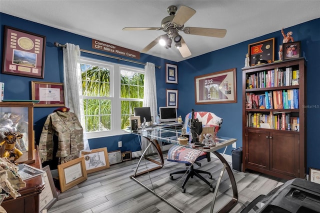 home office featuring ceiling fan and light hardwood / wood-style flooring