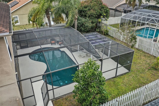 view of pool with a patio, glass enclosure, and a jacuzzi