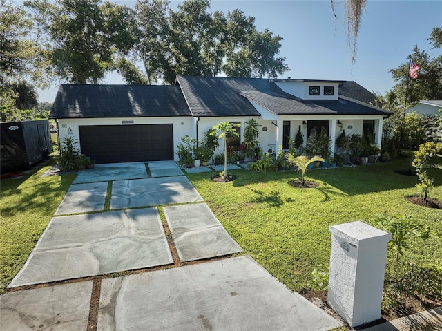 view of front of property with a front lawn, driveway, an attached garage, and stucco siding