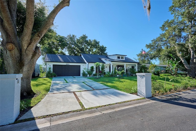 view of front of home with a garage, a front lawn, and concrete driveway