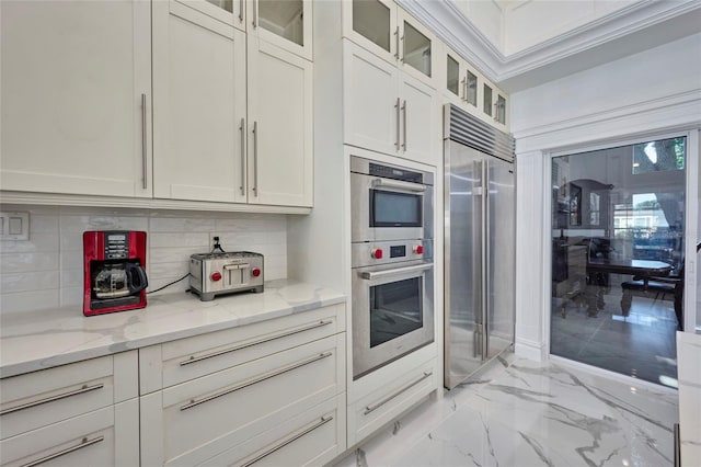 kitchen featuring stainless steel appliances, marble finish floor, white cabinets, and light stone counters