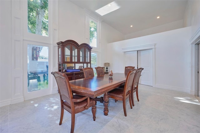 dining space with high vaulted ceiling, recessed lighting, marble finish floor, and baseboards