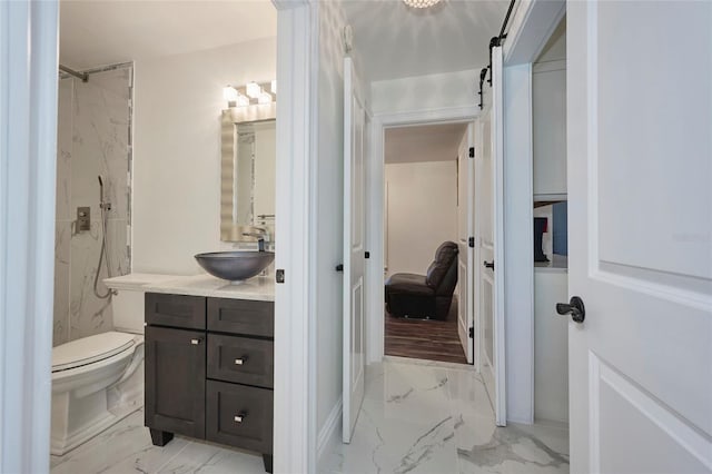 bathroom with toilet, marble finish floor, a marble finish shower, and vanity