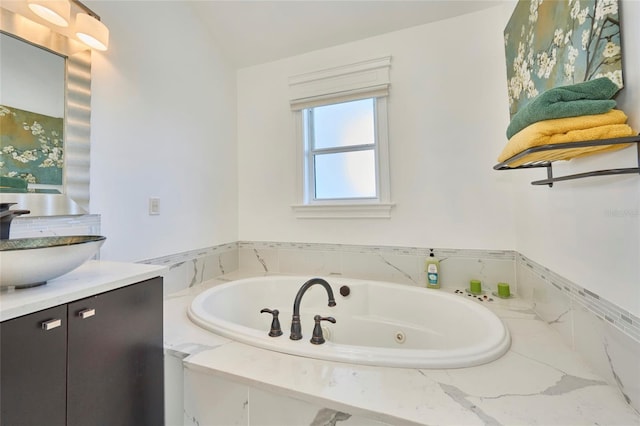 full bathroom with a jetted tub and vanity