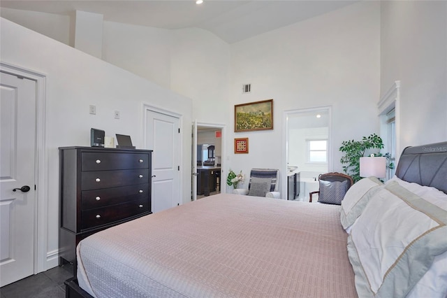 bedroom featuring high vaulted ceiling, dark tile patterned flooring, and visible vents