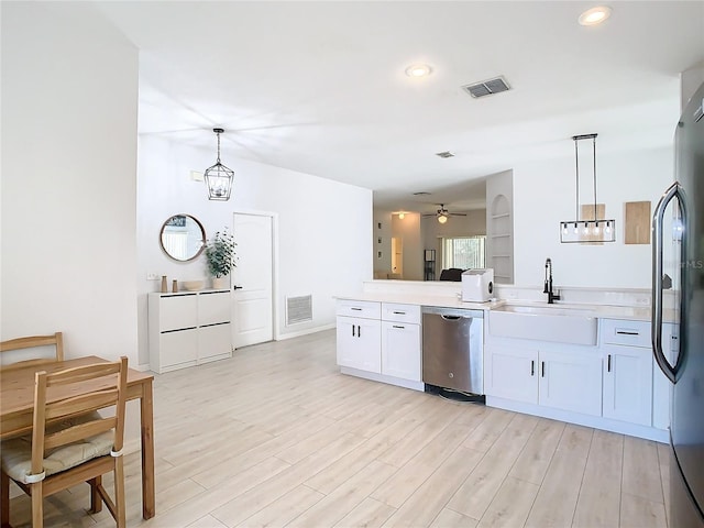 kitchen with hanging light fixtures, stainless steel dishwasher, sink, and white cabinets