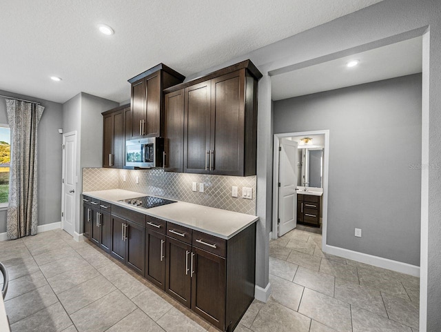 kitchen with black electric cooktop, decorative backsplash, dark brown cabinetry, and a textured ceiling