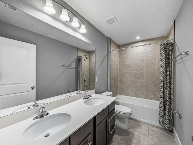 full bathroom with shower / bath combination with curtain, tile patterned flooring, vanity, toilet, and a textured ceiling