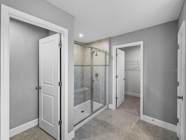 bathroom featuring an enclosed shower and a textured ceiling