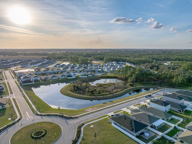 aerial view at dusk featuring a water view