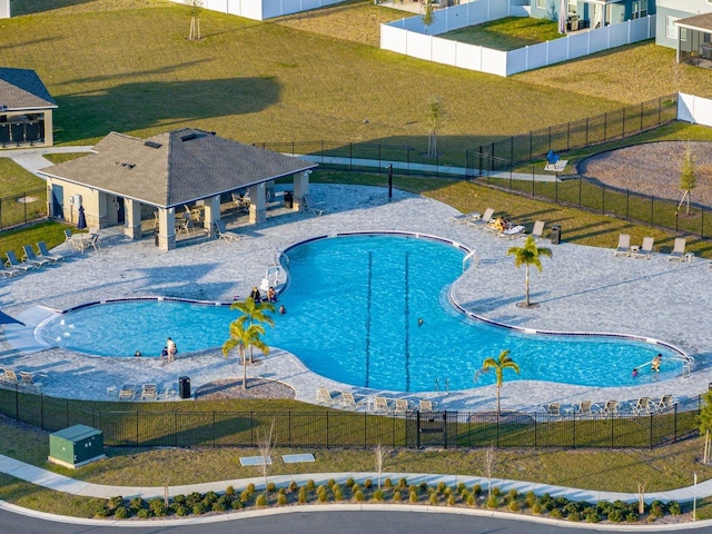 view of pool with a patio and a lawn