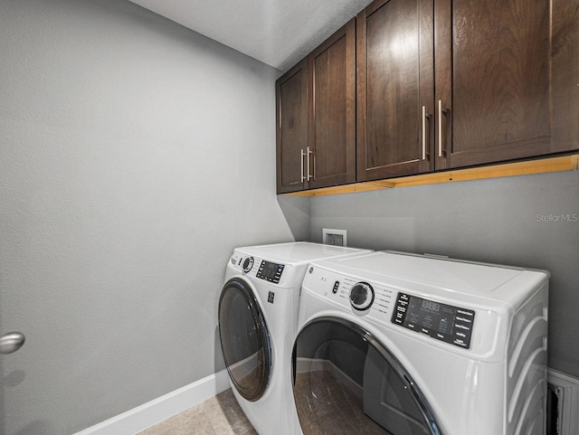 laundry area featuring washing machine and dryer and cabinets