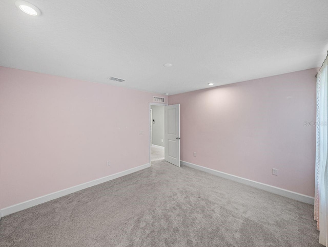 carpeted spare room featuring a textured ceiling