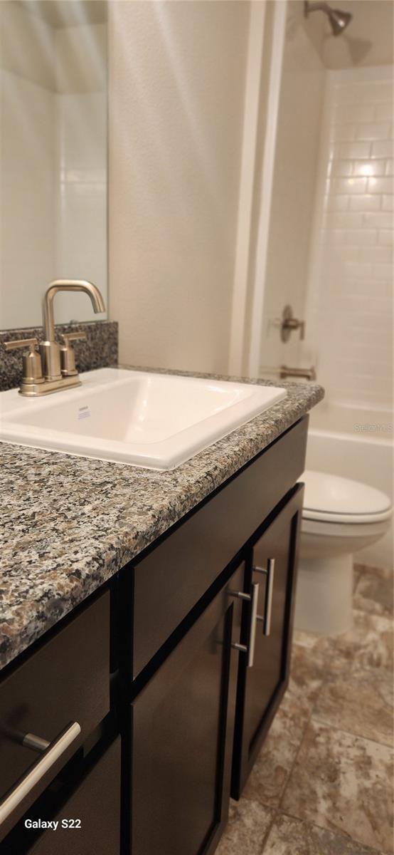 full bathroom featuring shower / tub combination, vanity, and toilet