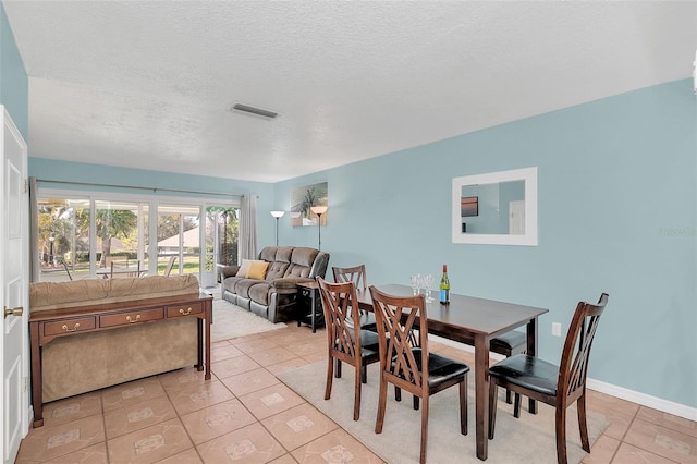 dining room with light tile patterned floors and a textured ceiling