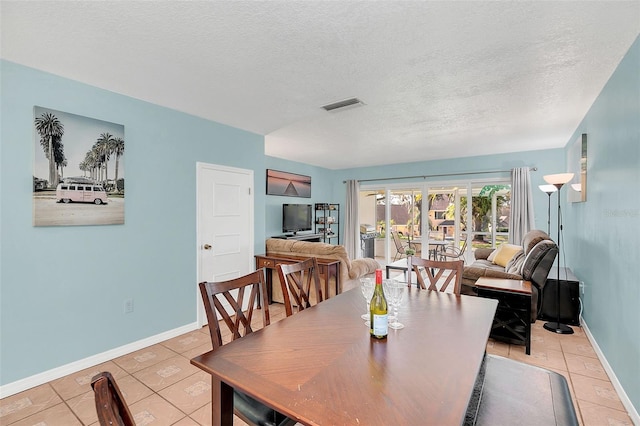 dining area with light tile patterned floors and a textured ceiling