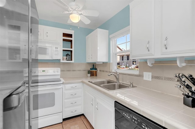 kitchen featuring sink, white appliances, backsplash, tile counters, and white cabinets